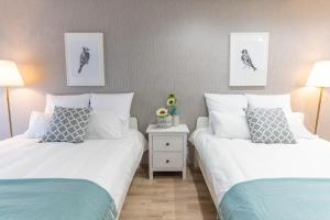 dwa łóżka siedzące obok siebie w sypialni w obiekcie Bijou Suites Cyan w Osace