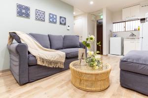 a living room with a couch and a table at Bijou Suites Cyan in Osaka