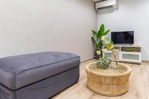 a living room with a couch and a table at Bijou Suites Cyan in Osaka +31 photos