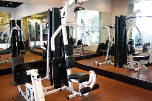 a gym with a bunch of tread machines in it at Akmani Hotel Jakarta in Jakarta