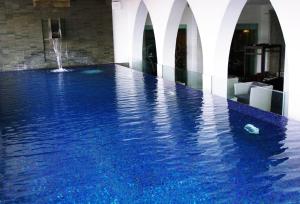 a swimming pool with a fountain in the middle of a building at Akmani Hotel Jakarta in Jakarta