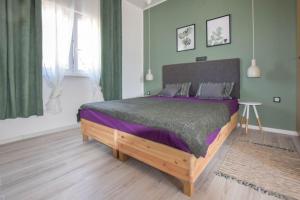 1 dormitorio con 1 cama grande con sábanas moradas en Peaceful home Olea oblica, en Primošten