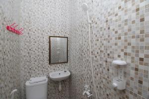 a bathroom with a toilet and a sink and a mirror at MAMA SYARIAH @ KUTAJAYA in Tangerang +33 photos