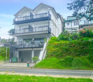 a white building with a balcony on the side of it at Galaxy Grand Hotel in Nuwara Eliya