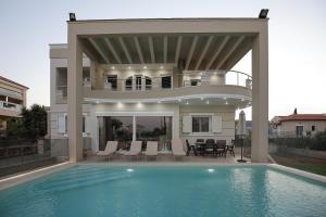 a villa with a swimming pool and a balcony at Cedar Tree Villa in Kounoupidhianá