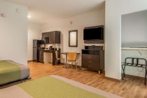 a bedroom with a bed and a desk with a television at Studio 6 Lake Charles in Lake Charles