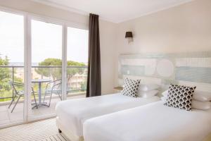 a hotel room with two beds and a balcony at Best Western Plus Antibes Riviera in Antibes