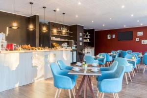 昂蒂布的住宿－安提伯萊維拉貝斯特韋斯特優質酒店，一间设有蓝色椅子的餐厅和一间酒吧