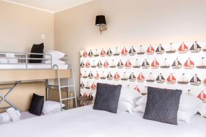 a room with two beds and a wall of sailboats at Best Western Plus Antibes Riviera in Antibes