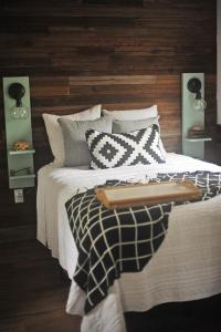 1 dormitorio con 1 cama con almohadas blancas y negras en The Harmony Oaks Homestead, en Masaryktown