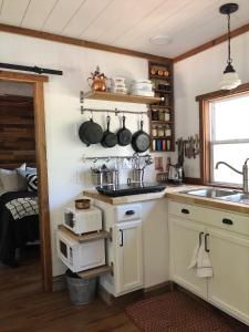 Il comprend une cuisine équipée d'un évier et d'une cuisinière. four supérieur dans l'établissement The Harmony Oaks Homestead, à Masaryktown