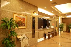 a lobby of a hospital with a counter and benches at Hotel Route-Inn Tomakomai Ekimae in Tomakomai
