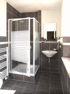 a bathroom with a glass shower and a sink at Hotel Augsburg Goldener Falke in Augsburg