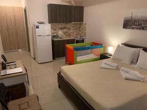 una stanza con un letto e una cucina con un frigorifero di Serenity Studios a Kala Nera