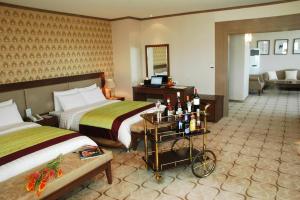 a hotel room with two beds and a table with bottles at Sunjin Grand Hotel in Ulaanbaatar