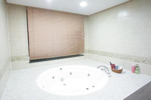 ein Bad mit einer großen weißen Badewanne in einem Zimmer in der Unterkunft Sunjin Grand Hotel in Ulaanbaatar