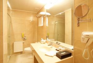uma casa de banho com um lavatório, um WC e um espelho. em Sunjin Grand Hotel em Ulan Bator