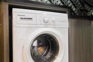 Un lave-linge blanc est installé dans une pièce. dans l'établissement 1BR with Working Space The Oasis Cikarang By Travelio, à Cikarang
