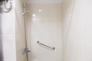 La salle de bains est pourvue d'une douche avec rideau de douche. dans l'établissement 1BR with Working Space The Oasis Cikarang By Travelio, à Cikarang 10 autres photos