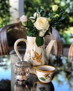 a vase with flowers and a cup of coffee on a table at Conacul Paloși in Horezu