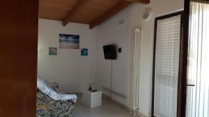 un soggiorno con sedia e TV a parete di Chalet in campagna a Città Sant'Angelo