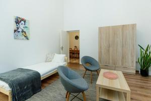1 dormitorio con 1 cama, 2 sillas y mesa en SOPHIE Apartman, en Eger