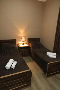 Zimmer mit 2 Betten und einem Tisch mit einer Lampe in der Unterkunft kutaisi Sunrise in Kutaissi