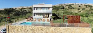 a house on a hill with a swimming pool at Vila Nainer in Pag