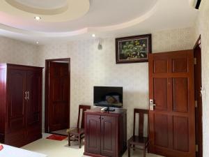 a room with wooden doors and a tv on the wall at Minh Kieu Hotel in Mỹ Tho