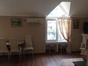 een woonkamer met een tafel en stoelen en een raam bij Pod evkaliptom Apartment in Gagra