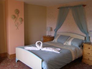 a bedroom with a bed with a white towel on it at Stone House Farm (Adults Only) in Lyng