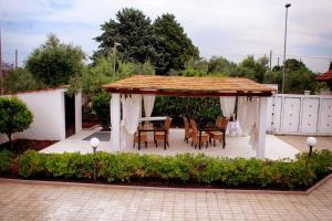 a gazebo with a table and chairs on a patio at TENUTA SERENA - Maison de Charme in Molfetta
