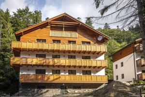 a large wooden house with a balcony at Apartmánový dom Poludnica - Chopok Juh in Tale