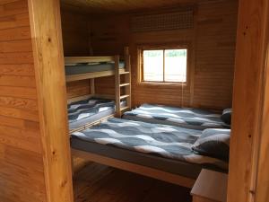 two bunk beds in a cabin with a window at Ežmalas in Rembate