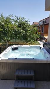 a jacuzzi tub on a patio with two benches at Rooms Katarina in Poreč