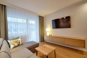 a living room with a couch and a flat screen tv at Apartament Waterway PREMIUM in Kołobrzeg