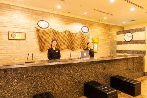 two women standing at a counter in a lobby at Hotel Terrace The Square Hitachi in Hitachi