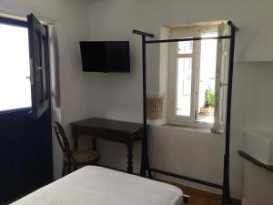 a bedroom with a bed and a desk and a window at Katina's garden studio in Tinos