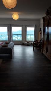 a bedroom with a bed and two large windows at Les ô welches côté lac in Orbey