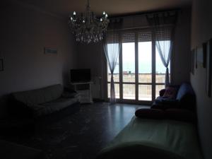 a living room with a chandelier and a large window at Casa Alessandra in Lerici