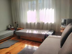 a bedroom with a bed and a tv and a window at Pokoje u Kamy in Ustka