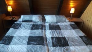 ein Bett mit einer blau-weißen Decke drauf in der Unterkunft Haus Heimathafen Fedsiel in Butjadingen