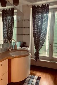 uma casa de banho com uma banheira, um lavatório e uma janela em A casa di Hugo em Marano di Valpolicella
