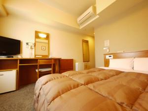 a hotel room with two beds and a desk at Hotel Route-Inn Fukaya Ekimae in Fukaya