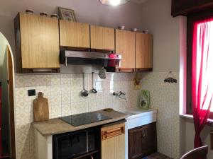 a kitchen with wooden cabinets and a counter top at Da Duccio e Maria in Acceglio