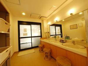 a bathroom with two sinks and a large mirror at Hotel Route-Inn Fukaya Ekimae in Fukaya