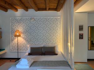 um quarto com uma cama branca e uma parede em A casa di Hugo em Marano di Valpolicella