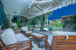 een patio met 2 stoelen, een tafel en een bank bij Villa Stevan in Sveti Stefan