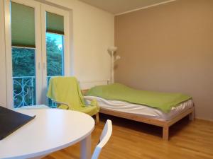 Cette chambre comprend un lit, une table et des chaises. dans l'établissement Apartament Monika, à Sopot