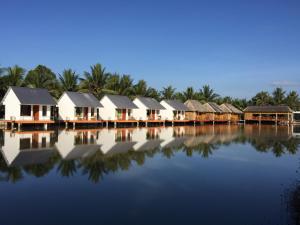 una fila di case su un corpo d'acqua di Tra Vinh Lodge a Nguyệt Hạng